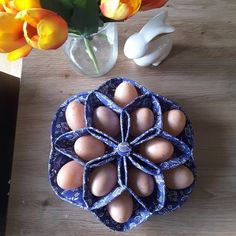 an arrangement of eggs on a table with tulips