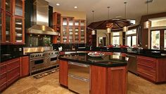 a large kitchen with stainless steel appliances and wooden cabinets