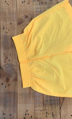 "High waisted 90's windbreaker shorts. High waist and looser through hips and thighs. Full elastic waistband. These shorts are bright neon yellow which is a hard color to pick up in photos. Shorts are in excellent clean condition. Measurements (taken zipped or buttoned up and laid comfortably flat) inches Tag Size Small Waist 24\"~27\"(stretch) Hips 40\"(loose) Length 15.5\" Inseam 4\" Rise 13.5\" Top thigh circumference 27\" All items are free of rips, tears, holes, and stains unless otherwise Streetwear High-waisted Shorts With Elastic Waistband, Summer Streetwear Athletic Shorts With Elastic Waistband, High-waisted Elastic Waistband Shorts For Streetwear, High-waisted Athletic Shorts For Spring Streetwear, Summer Streetwear Stretch Parachute Pants, Summer Stretch Parachute Pants For Streetwear, Sporty Cotton Parachute Pants For Summer, Spring Streetwear Shorts With Elastic Waistband, Spring Athletic Shorts With Elastic Waistband For Streetwear