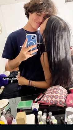 two people taking a selfie in front of a mirror with makeup and cosmetics on it