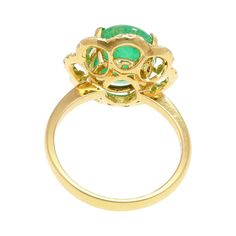 Natural Emerald and Diamond Flower Ring.   This cocktail ring features a bright rich green, 3.60-carat emerald center stone. The emerald is cabochon cut and secured in a prong setting. The emerald is adorned with 32 round-cut diamond floral motif halo, which share a weight of 0.30 carats total. The diamonds are superbly white and eye clean. All set in 18k solid yellow gold, with a tapered shank and intricate detailing along the base of the ring.   Item Details: - Type: Cocktail Ring  - Metal: 18K Yellow Gold  - Weight: 4.31 grams  - Setting: Prong  - Size: 6  - Face Measurements: 16.7 x 15.5 mm  _______________________  Center Stone Details: - Type: Emerald  - Carat: 3.60  - Cut: Cabochon  - Color: Green  _______________________  Side Stone Details:  - Type: Diamond  - Carat: 0.30 CTTW  - Classic Diamond Cabochon Emerald Ring, Fine Jewelry Emerald Cabochon Ring In 14k Gold, Luxury Cabochon Emerald Ring With Diamonds, Green Flower-shaped Emerald Jewelry, Luxury Gold Emerald Cabochon Ring, Flower Halo, 18k Gold Ring, Diamond Flower, Natural Emerald