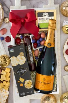 a bottle of wine, crackers and cheese in a gift box