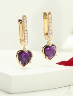 Heart-cut Amethyst earrings adorned with a cascade of diamonds, each one a reflection of the magnificent heart at its core. With every move they dance and shimmer and create an alluring aura of glamour and sophistication. Expertly crafted, the Lover's Rock Hoop Earrings feature a total gross weight of 7.28 grams, with a durable metal weight of 5.5 grams. Adorned with a stunning 8.29 carat gemstone and sparkling 0.62 carat cubic zirconia, these elegant earrings radiate sophistication and romance. Luxury Heart Cut Diamond Earrings, Luxury Cubic Zirconia Heart Earrings For Formal Events, Luxury Heart-shaped Brilliant Cut Earrings, Luxury Gemstone Hoop Earrings, Luxury Heart Cut Earrings With Prong Setting, Luxury Heart-shaped Diamond Earrings, Luxury Heart Cut Earrings With Diamond Accents, Elegant White Gold Huggie Heart Earrings, Luxury Diamond Heart Earrings For Gift