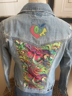 "Love and Peace Aeropostale distressed denim jacket is embellished with groovy psychedelic fabric on the back panel and above on the yoke is a \"love\" design that's colors complement the fabric. This jacket is distressed, the edges of the collar, pocket flaps, waistband, yoke, and hem are very raw that truly makes this jacket perfect for a Boho look.  Aeropostale Size M no fabric content label available Measurment's Chest 35\" Sleeve 23 3/4\" Shoulder 15 1/2\" Length 20 3/4\"" Multicolor Denim Jacket With Patches For Spring, Multicolor Patched Denim Jacket For Spring, Fitted Multicolor Denim Jacket For Streetwear, Artsy Long Sleeve Cotton Denim Jacket, Multicolor Graphic Print Denim Jacket For Spring, Fitted Acid Wash Denim Jacket For Spring, Trendy Fitted Acid Wash Denim Jacket, Artsy Cotton Denim Jacket For Spring, Hippie Cotton Denim Jacket For Fall