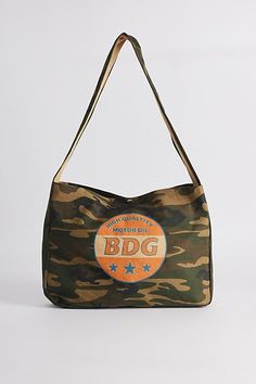 Camo pattern sling bag by BDG from UO with a logo graphic printed at the front. Snap top bag with a shoulder strap. Urban Outfitters exclusive. Features BDG graphic sling bag Camo pattern canvas bag BDG logo graphic Snap closure Shoulder strap UO exclusive Content + Care 100% Cotton Spot clean Imported | BDG Graphic Sling Bag in Green at Urban Outfitters Casual Logo Print Shoulder Bag For Travel, Casual Shoulder Bag With Logo Print For Travel, Travel Shoulder Bag With Logo Print Tote Shape, Casual Travel Shoulder Bag With Logo Print, Travel Tote Shoulder Bag With Logo Print, Canvas Tote Shoulder Bag With Logo Print, Casual Shoulder Bag With Logo For Daily Use, Travel Cotton Shoulder Bag With Logo Print, Travel Shoulder Bag With Logo Print In Cotton