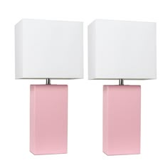 two pink lamps with white shades on them