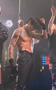 a shirtless male performing on stage at a concert