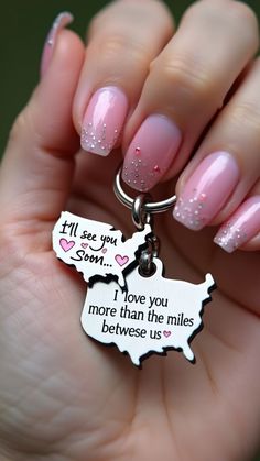 a woman's hand holding a keychain that says i love you more than the miles between us