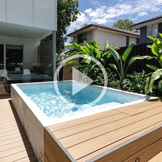 an above ground pool surrounded by greenery and wooden decking in front of a house