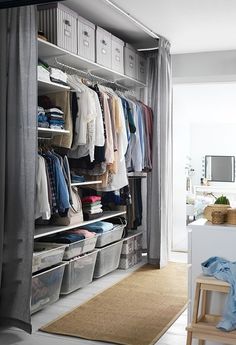 an organized closet is shown with clothes and other items in bins on the shelves