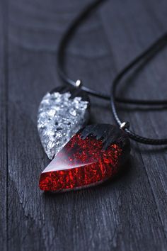 two red and silver pendants sitting on top of a wooden table