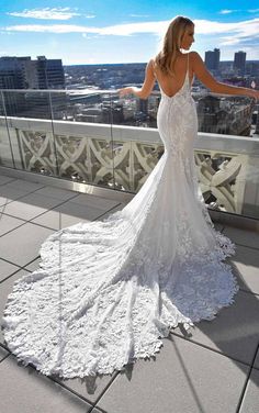 a woman standing on top of a building wearing a wedding dress