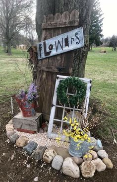 an old door is sitting in the middle of a yard with flowers growing out of it