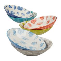 three bowls with different designs on them sitting side by side in the shape of seashells