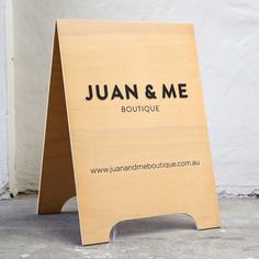 a wooden sign that says juan & me boutique on it's front and side