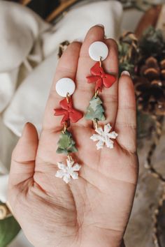 a person is holding some christmas decorations in their hand and it looks like they are wearing bows