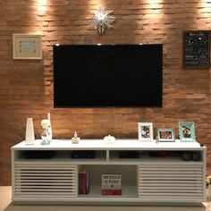 an entertainment center with a flat screen tv mounted on the wall and various decorations around it