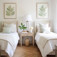 two beds in a bedroom with white sheets and pillows