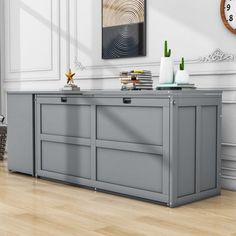 a room with a large gray cabinet and clock on the wall next to wooden flooring