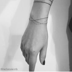 a woman's hand with a small tattoo on the wrist and an arrow in the middle