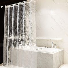 the shower curtain is made out of silver foil and sits next to a white bathtub