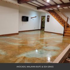 an empty living room with wood floors and stairs in the center is painted brown, white and blue