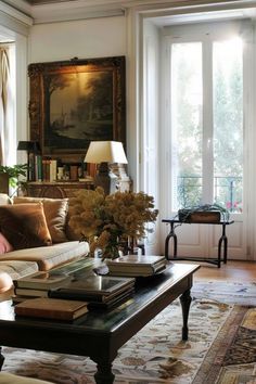 a living room filled with furniture and a painting on the wall above it's windows