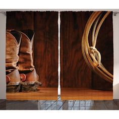 a pair of cowboy boots sitting on top of a wooden floor next to a rope