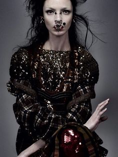 a woman with long hair and piercings on her nose is posing for the camera