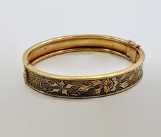 This is a Victorian Revival, hinged bangle from the. 1930's - 40's. I love this bracelet both in style and condition! It is 12K gold filled.  This has a beautiful etched and textured pattern to it. It features a floral pattern.  The background has a texture to make the flower stand out. It features a slide clasp that is in perfect working order with an attached safety latch for extra protection. Beautiful piece on its own or stack it with more for a statement look.  If you want a pair, I have a second one listed!  Condition: Very good vintage condition, vintage patina consistent with age - I do not see any wear! Measurements: 0.43" or 10.71 mm wide; inside measurement 7" around Weight: 17.2 grams Markings: 1/20 12KTGF and what looks like 3 initials that I cannot make out Please examine pho Vintage Hinged Bangle For Formal Occasions, Luxury Victorian Bangle For Anniversary, Vintage Hinged Bangle As Gift, Luxury Victorian Etched Bangle, Luxury Victorian Etched Bracelets, Luxury Victorian Engraved Cuff Bracelet, Vintage Hinged Bangle Gift, Luxury Vintage Etched Bangle, Victorian Engraved Gold Bangle Bracelet