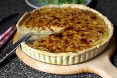 a quiche on a cutting board with a knife