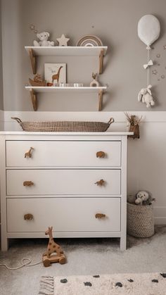 a baby's room with white furniture and toys