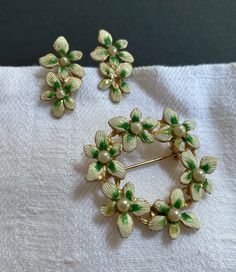 "Very sweet earrings brooch jewelry set; floral shape, white and green, with a faux pearl in the center,  Height of the earrings 1\" Diameter of the brooch 2 1/4\" Good vintage condition; one pearl went missing in one of the earrings (see photo) SHOP THE STORE:  https://www.etsy.com/shop/BrocanteBedStuy?" Sweet Earrings, Photo Shop, Enamel Brooch, Brooch Jewelry, Fall Accessories, Vintage Crafts, Floral Earrings, Screw Back Earrings, Vintage Accessories