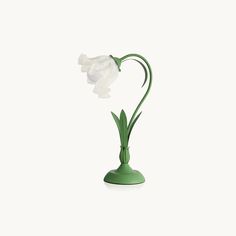 a green vase with a white flower in it's center on a white background