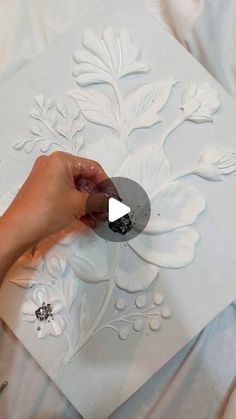 a person is painting a flower design on a piece of paper with acrylic paint