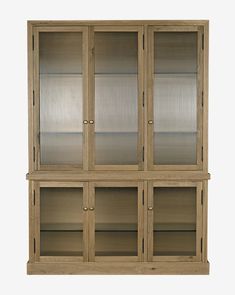 a wooden cabinet with glass doors on the front and bottom shelves in light brown wood