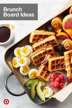 a pan filled with waffles and fruit next to a cup of coffee