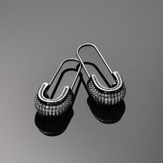 Safety pin jewelry is back in style and ready to add an edgy vibe to your looks. These sterling silver earrings are black rhodium plated and adorned with sparkling CZ accents.  If you are a fan of gothic jewelry, these black earrings will be an ideal addition to your collection. Make these Threader earrings your new go to pair of silver earrings. Nickel-free Black Punk Earrings, Black Sterling Silver Edgy Earrings, Black Edgy Sterling Silver Earrings, Black Nickel-free Punk Earrings, Edgy Black Sterling Silver Earrings, Black Punk Metal Earrings, Edgy Black Earrings For Streetwear, Black Edgy Earrings, Black Metal Earrings With Oxidized Finish