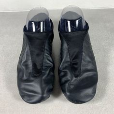 a pair of black shoes sitting on top of a white floor