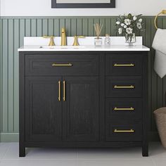 a bathroom vanity with two sinks and gold handles