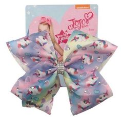 a pink and blue hair bow with unicorns on the side, in front of a card