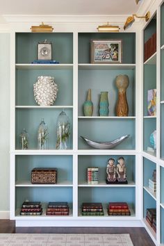 a white bookcase filled with lots of books and figurines on top of it