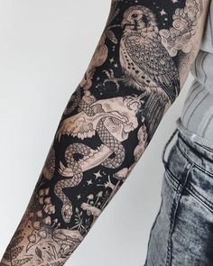 an owl and dragon tattoo on the arm