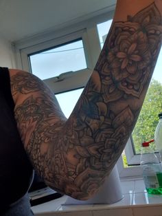 a woman with tattoos on her arm in the kitchen