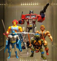 several action figures are displayed in a glass case