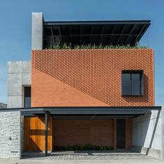 a brick building with an open garage door and grass growing out of the top window