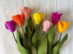 colorful felt flowers are arranged in a vase