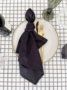 a plate with a napkin, fork and knife sitting on it next to other place settings