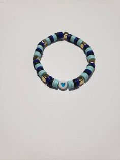 a beaded bracelet with blue and gold beads on a white surface, featuring a heart