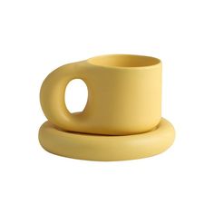 a yellow cup and saucer sitting on top of each other in front of a white background